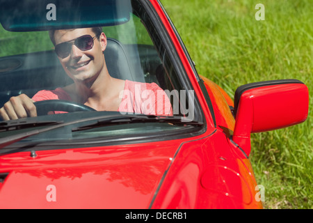 Smiling handsome man au volant de son cabriolet Banque D'Images