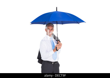 Businessman holding umbrella smiling at camera Banque D'Images