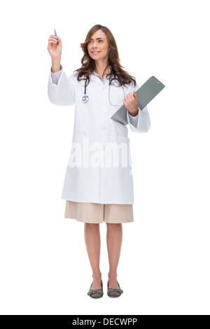 Brunette doctor holding clipboard and pointing at something Banque D'Images