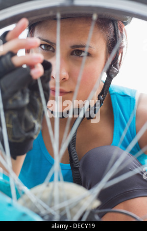 Femme à l'accent sur les rayons de roue de vélo Banque D'Images