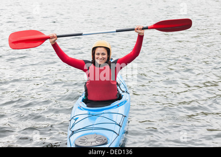 Smiling woman in a kayak cheering at the camera Banque D'Images