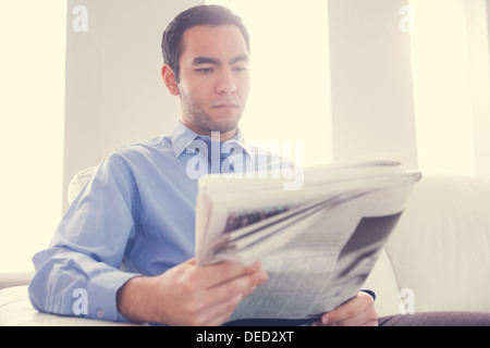 Handsome businessman reading newspaper