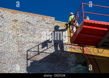 Detroit, Michigan - Un ouvrier répare la peinture sur un mur à l'Est de marché, la ville majeure du marché des producteurs. Banque D'Images