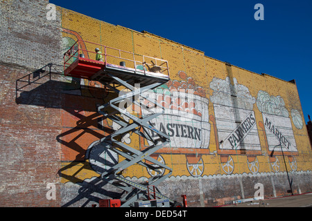 Detroit, Michigan - Un ouvrier répare la peinture sur un mur à l'Est de marché, la ville majeure du marché des producteurs. Banque D'Images