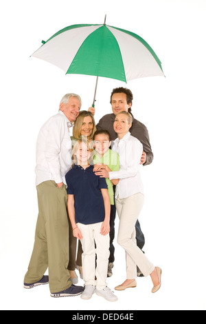 Trois générations family isolé sur fond blanc holding umbrella Banque D'Images