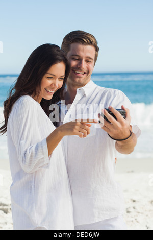 Happy couple looking at leur appareil photo Banque D'Images