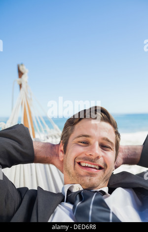 Smiling businessman relaxing in hammock Banque D'Images