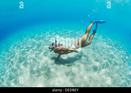 Sous l'image d'une femme plongée dans la mer tropicale sur fond de sable Banque D'Images