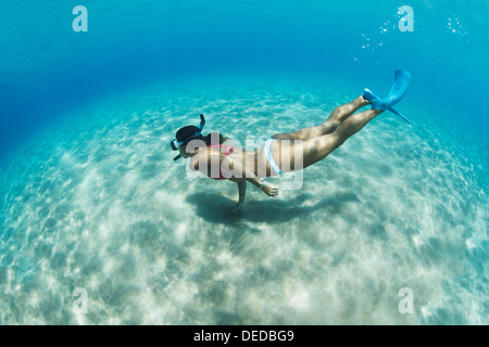 Sous l'image d'une femme plongée dans la mer tropicale sur fond de sable Banque D'Images