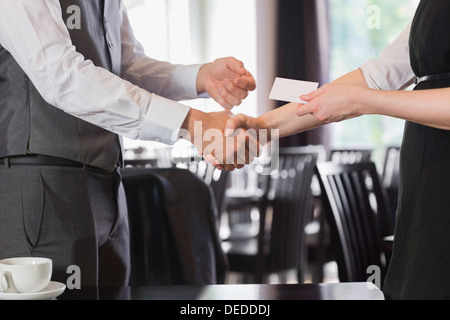 Les gens d'affaires se serrer la main après une rencontre et changer de carte Banque D'Images