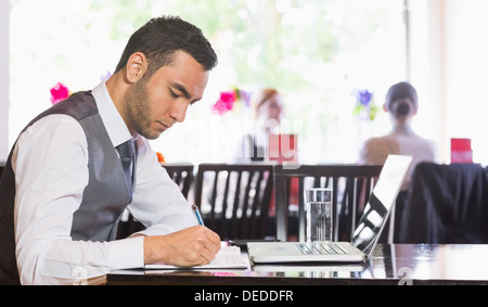 Homme d'écrire quelque chose concentré Banque D'Images