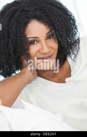 Portrait d'un beau milieu de African American Woman sitting at home relaxing Banque D'Images