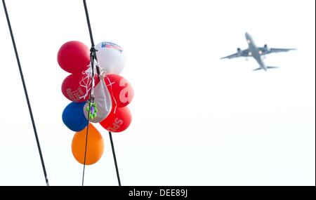 Un paquet de ballons publicitaires présentant les logos des différents partis politiques est pris dans une ligne électrique à Berlin, Allemagne, 17 septembre 2013. L'élection générale de la Bundestag va avoir lieu le dimanche 22 septembre 2013. Photo : Joerg Carstensen Banque D'Images