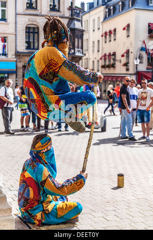 Les touristes regarder deux amuseurs publics effectuant un tour de lévitation dans la place d'armes, la Ville de Luxembourg. Banque D'Images