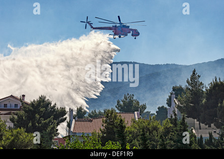 Un hélicoptère de lutte contre l'incendie éteint l'incendie plus de maisons Banque D'Images