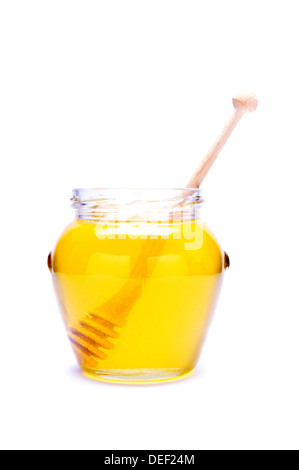 Verre de miel avec balancier en bois isolé sur fond blanc Banque D'Images