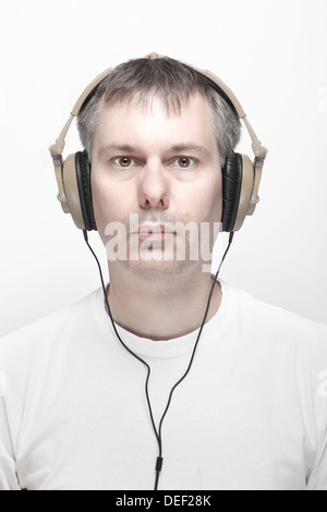 L'homme l'écoute de musique au casque, avec les yeux ouverts. Banque D'Images