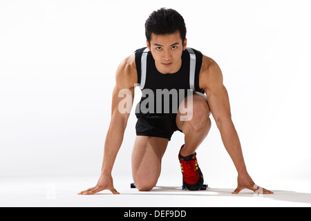 Homme runner sur blocs de départ, close-up Banque D'Images