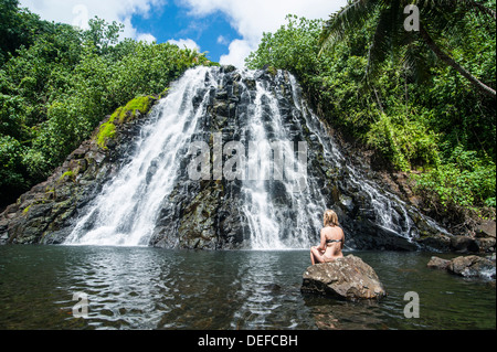 Femme assise en face de la chute d'Kepirohi, Pohnpei, États fédérés de Micronésie, Îles Carolines, Centre du Pacifique Banque D'Images