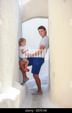 Jeune père avec sa fille peu dans le vieux village grec sur l'île de Santorin, Grèce Banque D'Images