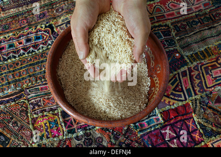 Tamiser le riz brun à long grain dans un bol. Banque D'Images