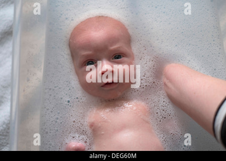 Un bébé nouveau-né été baigné par sa mère. Banque D'Images