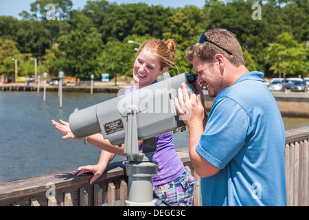 Le jeune homme regarde à travers le dispositif de visualisation de la nouvelle bague de fiançailles sur le doigt de son fiancÃƒÆ’Ã‚Â©Ãƒâ€šÃ‚Â©©sur la jetée de Fairhope, Alabama Banque D'Images