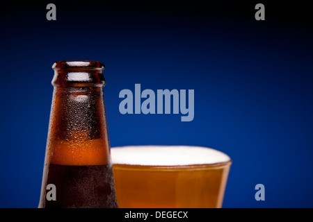 Gros plan sur une bouteille de bière et un verre plein. Banque D'Images