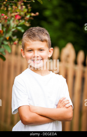 Boy crossing arms and smiling Banque D'Images