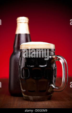 Un verre et une bouteille de bière sur une table en bois. Banque D'Images