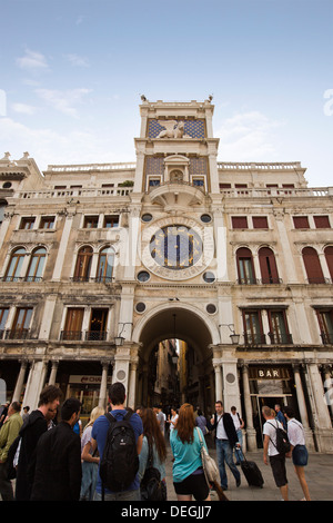 Les touristes en face d'une tour de l'horloge, la tour de l'horloge, la Place Saint Marc, Venise, Vénétie, Italie Banque D'Images