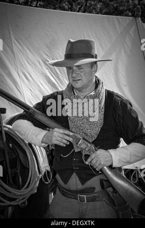 Philip armés Twaites Cowboy, tenant une à chargement par simple passe-levier actionné carabine arme utilisée par l'armée britannique à Ingleton's Wild West-end UK Banque D'Images