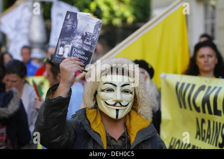 Dublin, Irlande. 18 septembre 2013. Un manifestant est photographié, le port d'un masque de Guy Fawkes et tenant un livre à propos de Dublin de cour. Les manifestants tenir une assemblée du peuple à l'extérieur du Dail (Parlement irlandais), l'austérité pour discuter en petits groupes. L'Assemblée générale faisait partie d'une journée de manifestations pour coïncider avec le retour de la TDs (membres du Parlement) de leurs vacances d'été. Crédit : Michael Debets/Alamy Live News Banque D'Images