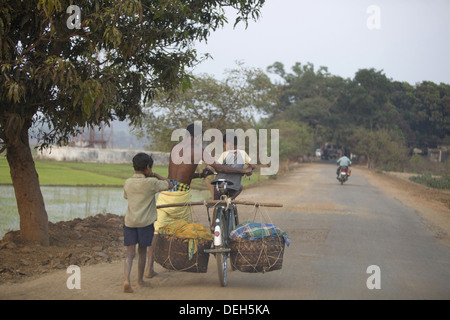 Père et fils comptable charge sur cycle, Orissa, Inde Banque D'Images