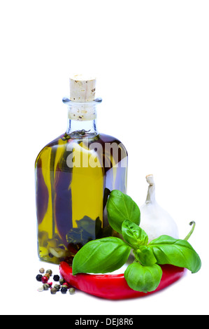 Bouteille d'huile d'olive infusée avec poivre, piment, ail et basilic isolé sur fond blanc Banque D'Images