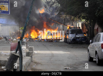 Le Caire, Le Caire, Égypte. 19e Août, 2013. Les Égyptiens devant une voiture de police en feu en face d'al-Zamalek le siège au Caire du 19 au 19 mai 2013. Les membres d'un groupe de fans hardcore du Zamalek football club, l'Ultra White Knights (UWK), pris d'assaut le siège du club au Caire le jeudi après une protestation exigeant des changements à la direction du club Crédit : Ahmed Asad APA/Images/ZUMAPRESS.com/Alamy Live News Banque D'Images