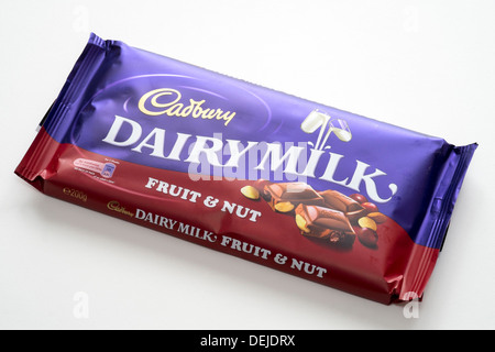 Bar de fruits lait Cadbury non ouvert et l'écrou de l'enrubanneuse de chocolat sur fond blanc Banque D'Images