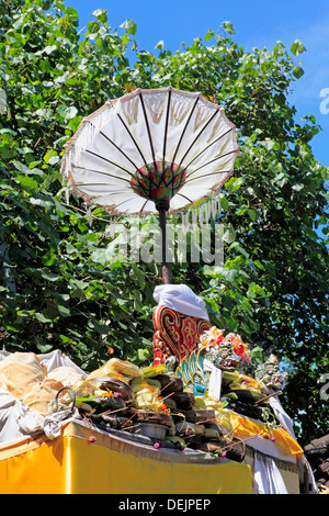 Pile d'offrandes au temple sur un temple avec une statue de dragon et parapluie. Sanur, Bali, Indonésie Banque D'Images