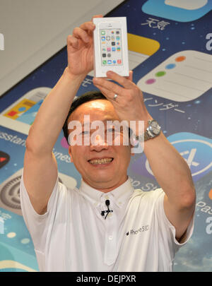 Tokyo, Japon - Président Kaoru Kato de NTT Docomo tient fièrement le paquet d'un nouvel iPhone à un Docomo shop à Tokyo que les ventes de la dernière Apple Iphone commence à travers le Japon le vendredi 20 septembre, 2013. Après avoir cessé de perdre sa part de marché à ses concurrents - Softbank et KDDI. 20e Août, 2013. Avec l'Apple smartphones dans leurs compositions, le premier fournisseur de téléphonie mobile a maintenant rejoint ses rivaux dans la vente d'Iphone. Docomo's déménagement aura probablement un coup dur pour les fabricants de smartphones japonais tels que Sony Corp. Fujitsu Ltd. et Sharp Corp. Crédit : Natsuki Sakai/AFLO/Alamy Live N Banque D'Images