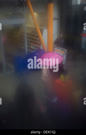 Vu à travers la fenêtre table-condensation, passagers attendent à un arrêt d'autobus au cours de l'humidité, par temps sombre, au centre de Londres. Banque D'Images