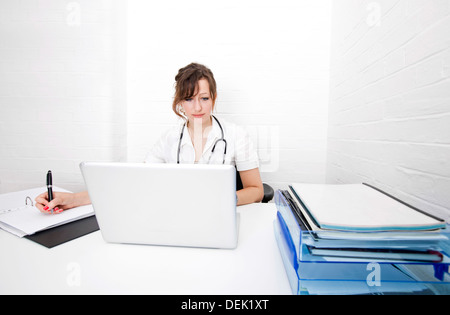 Jeune femme d'écrire des notes sur 24 clinic Banque D'Images