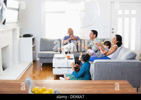 Famille regardent la télévision ensemble dans la salle de séjour Banque D'Images