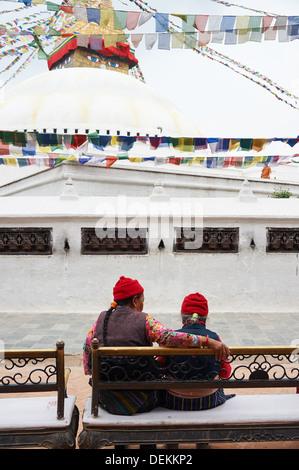 Deux femmes népalaises s'asseoir à côté de chat Boudhanat du Népal, plus grand Stupa du bouddhisme tibétain, Katmandou Banque D'Images