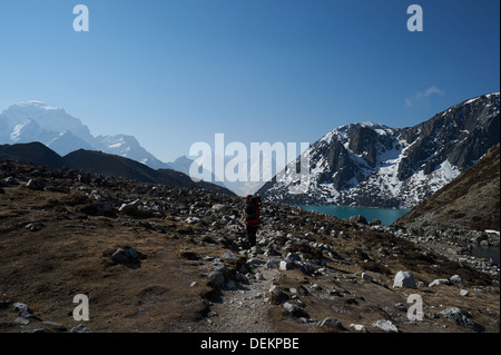 Porter un sherpa porte une charge lourde à environ 4700m d'altitude, est dirigé vers le sud sur la piste de Gokyo village, au Népal. Banque D'Images