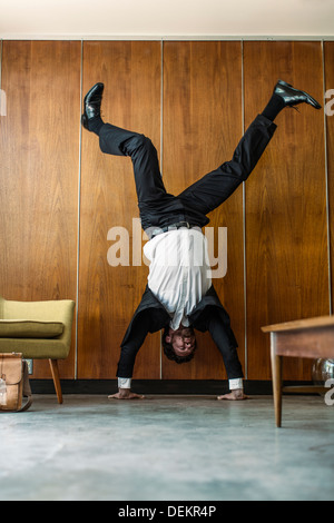 Caucasian businessman doing handstand Banque D'Images