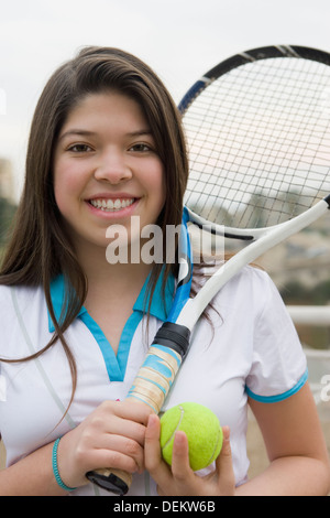 Hispanic girl playing tennis outdoors Banque D'Images