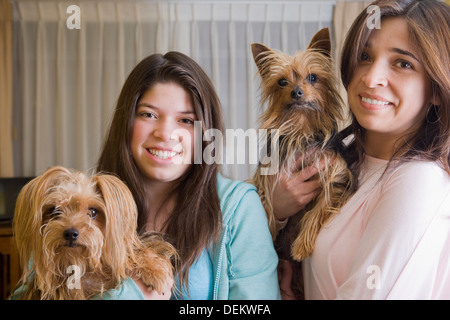 Hispanic mother and daughter holding dogs Banque D'Images