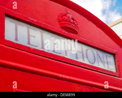 Détail de la partie supérieure d'un vieux téléphone rouge britannique fort Création K6 montrant le téléphone signe et couronne. Banque D'Images