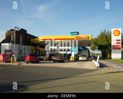 Un shell, en bordure de la station d'essence libre-service à l'intérieur du Royaume-Uni, avec des voitures le plein de carburant dans l'avant-cour. Banque D'Images