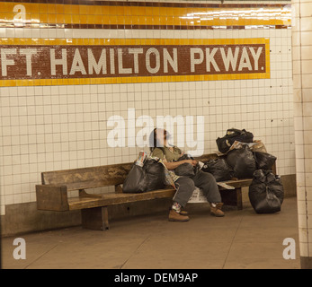 Sans-abri avec ses biens sur la plate-forme à une station de métro à Brooklyn, New York. Banque D'Images